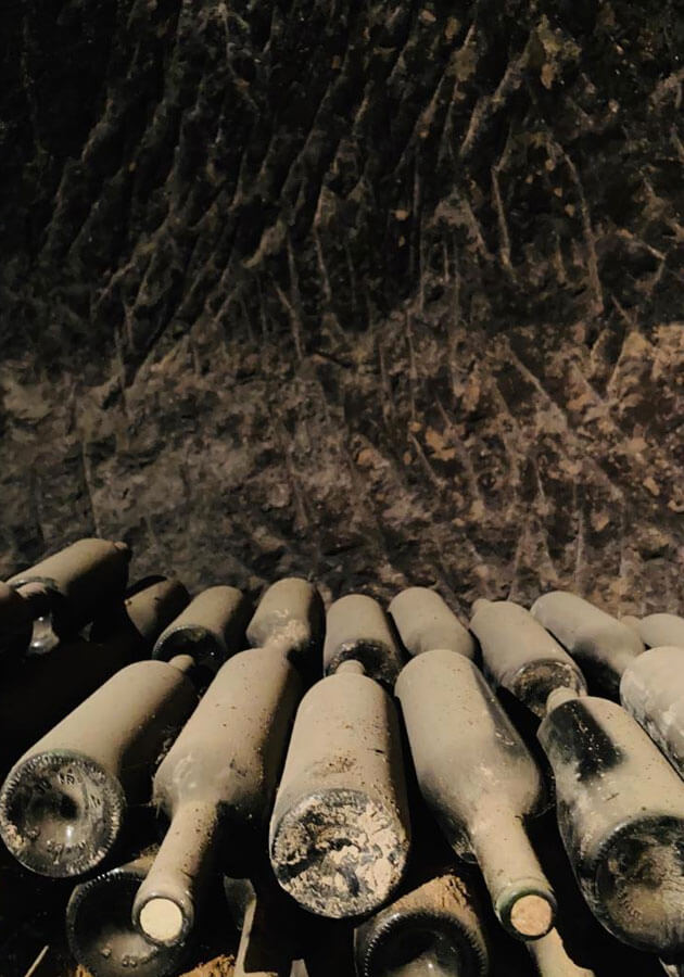 Viejas botellas en el calado de la bodega tradicional de Queirón en Quel